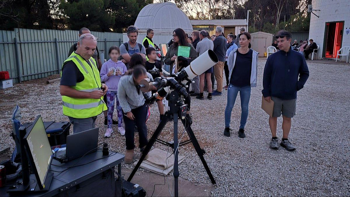 Visitors looking through a telescope at an ASSA observing event